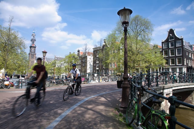 Police bicyclist crossing a bridge over the Prinsengracht.