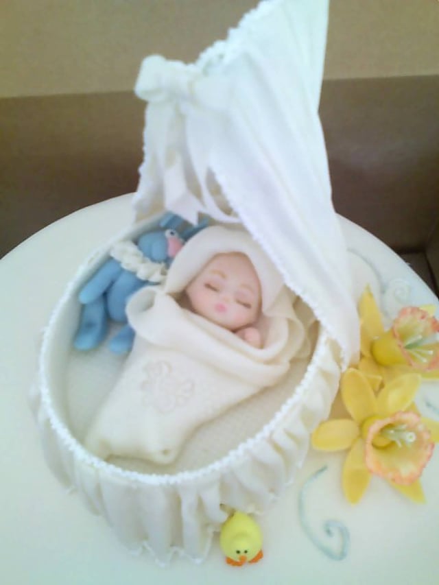 Cake made for a baby shower with edible decorations, an example of edible art