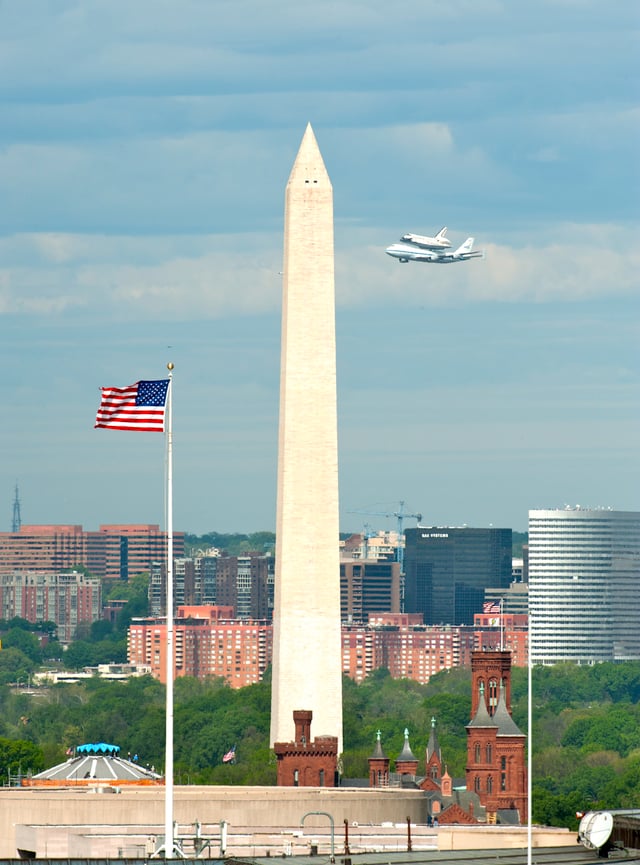 The Space Shuttle Discovery and the Washington Monument prior to landing at Dulles International Airport