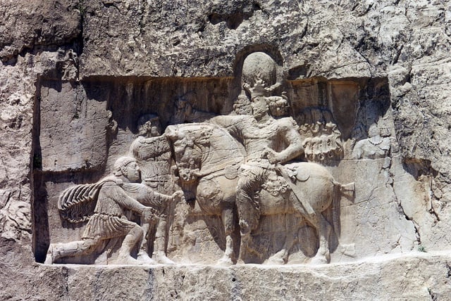 Rock-face relief at Naqsh-e Rustam of Iranian emperor Shapur I (on horseback) capturing Roman emperor Valerian (kneeing) and Philip the Arab (standing).