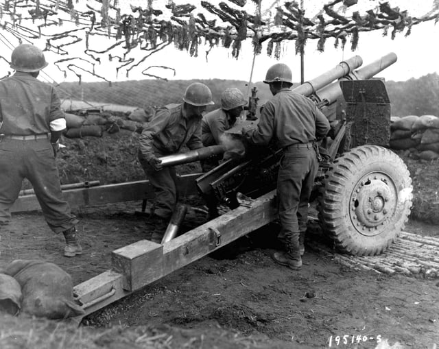 A team of Japanese-American G.I.s from the 522nd Field Artillery Battalion throw 105mm shells at Germans in support of an infantry attack in Bruyères, France.