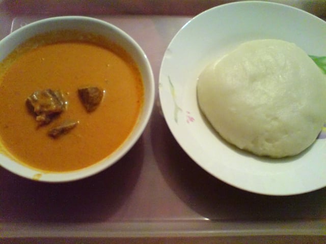 A plate of fufu (right) accompanied with peanut soup.