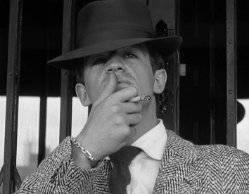 As car thief Michel Poiccard, a.k.a. Laszlo Kovacs, Jean-Paul Belmondo in À bout de souffle (Breathless; 1960). Poiccard reveres and styles himself after Humphrey Bogart's screen persona. Here he imitates a characteristic Bogart gesture, one of the film's motifs.