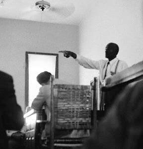 Till's uncle, Mose Wright, identifying J. W. Milam during Milam's trial, an act which "signified intimidation of Delta blacks was no longer as effective as the past". Wright had "crossed a line that no one could remember a black man ever crossing in Mississippi."  Photojournalist Ernest Withers defied the judge's orders banning photography during the trial to capture this shot.