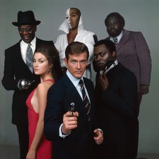 Promotional image of the cast of Live and Let Die. From left: Julius Harris, Jane Seymour, Geoffrey Holder, Roger Moore, Yaphet Kotto and Earl Jolly Brown