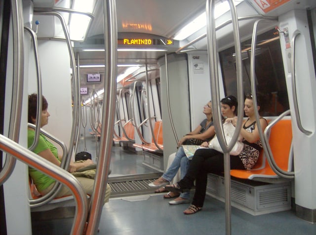 Interior of an S/300 train. The chevrons on the LED displays indicate that the doors will open on the right side of the train at Flaminio–Piazza del Popolo.