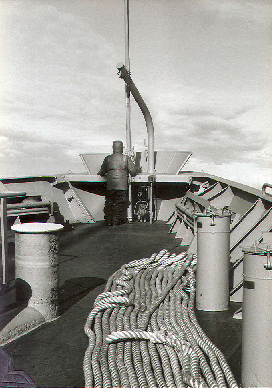 An able seaman stands iceberg lookout on the bow of the freighter USNS Southern Cross during a re-supply mission to McMurdo Station, Antarctica; circa 1981.