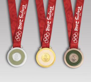 The reverse side of the medals of the 2008 Summer Olympics: silver (left), gold (center), bronze (right). Each medal has a ring of jade.