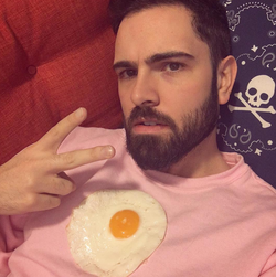 Photo of Adam Ellis with a fried egg on his chest.