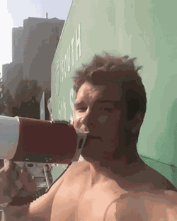 GIF of Dephree speaking on a megaphone while on top of a freeway sign*