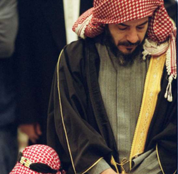 Irsan and his son pray at Reliant Center Hall A on Dec. 6, 2002, to observe the end of Ramadan and the beginning of Eid al-Fitr