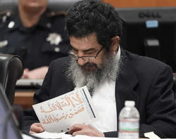 Ali Mahwood-Awad Irsan is shown in court on Monday, June 25, 2018 in Houston holding a paper written in Arabic and colored with orange marker of the mantra, "There is no god but God and Mohammad is God's Prophet."