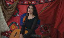 Photo of Bedouine with her guitar.