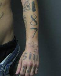 David Watson's "187" tattoo on his left forearm; and "SIN" tattoo on his left hand