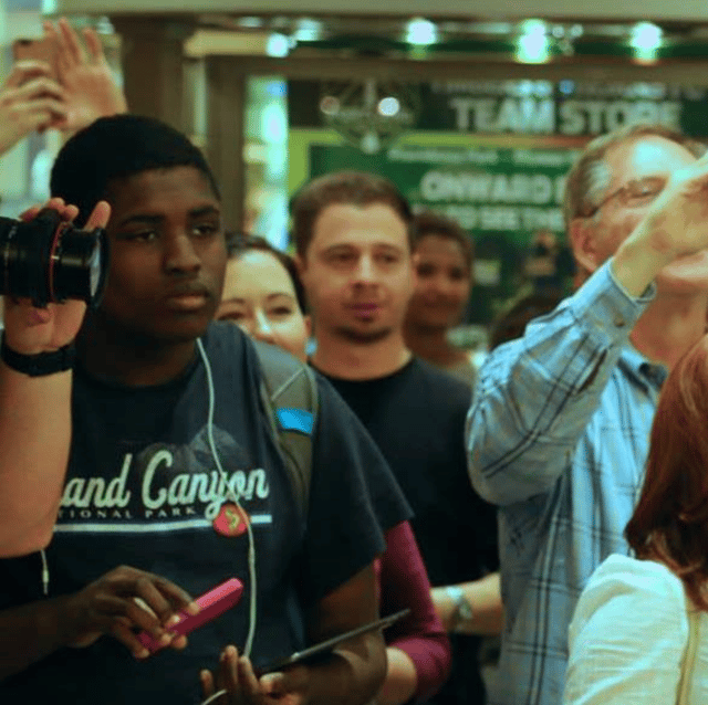 Photo of Deme filming an event.
