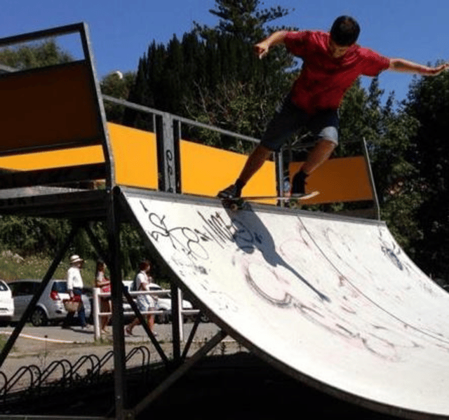 Ignacio rides a ramp at a skate park.