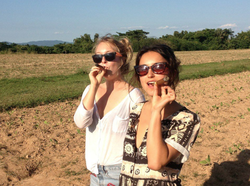 India Oxenberg with her friend walking and smoking cigars.
