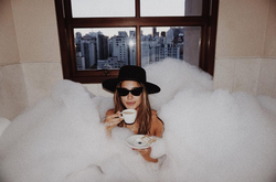 Photo of Jessica Serfaty inside of a bubbly bathtub.