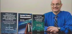 Photo of Jon M. Quigleyalongside the books he has written.