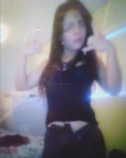 Photo of Josselin Ramirez flashing MS-13 gang signs while armed with a handgun