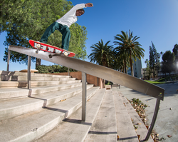 Photo of Kader Sylla doing a 50/50 rail grind.