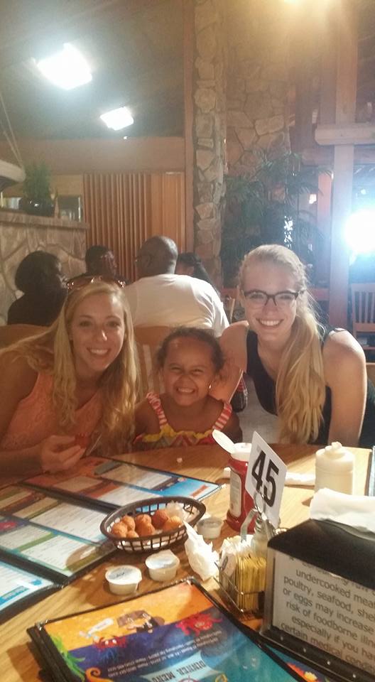 Photo of Kelsey and her sister Karli with family at dinner