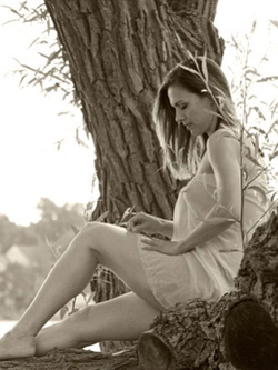 Sepia toned photo of Lauren Stuart where she is up in a tree.