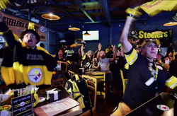 Pittsburg Steelers fans celebrate while watching the game at a restaurant.