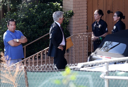 Photo of Mac Anderson standing outside of his home as the police investigate his residence.