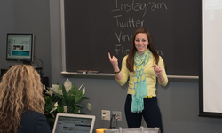 Meredith Sullivan Chapman presenting in front of a college classroom.