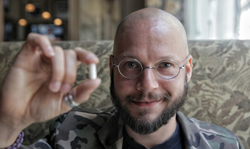 Photo of Michael Laufer showing off one his biohacking projects.