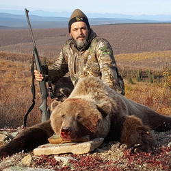 Photo of Mike Cronk with a dead bear.