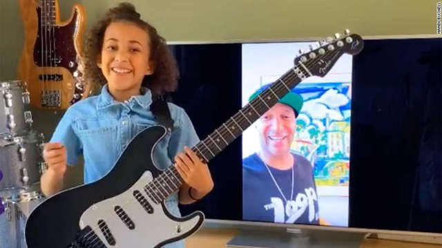 Nandi Bushell holds her new guitar from Tom Morello