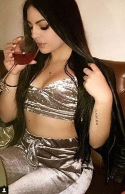 Photo of Natacha Rodrigues sipping from her glass of wine.