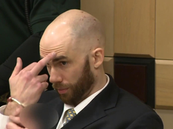 Peter Avsenew giving the victims' families' the middle finger after being sentenced to death