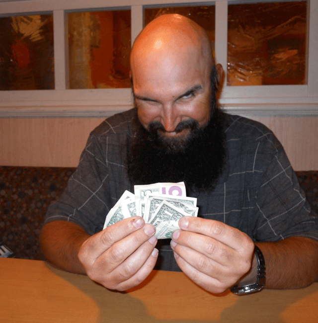 Photo of Wade holding dollar bills and looking really strange.