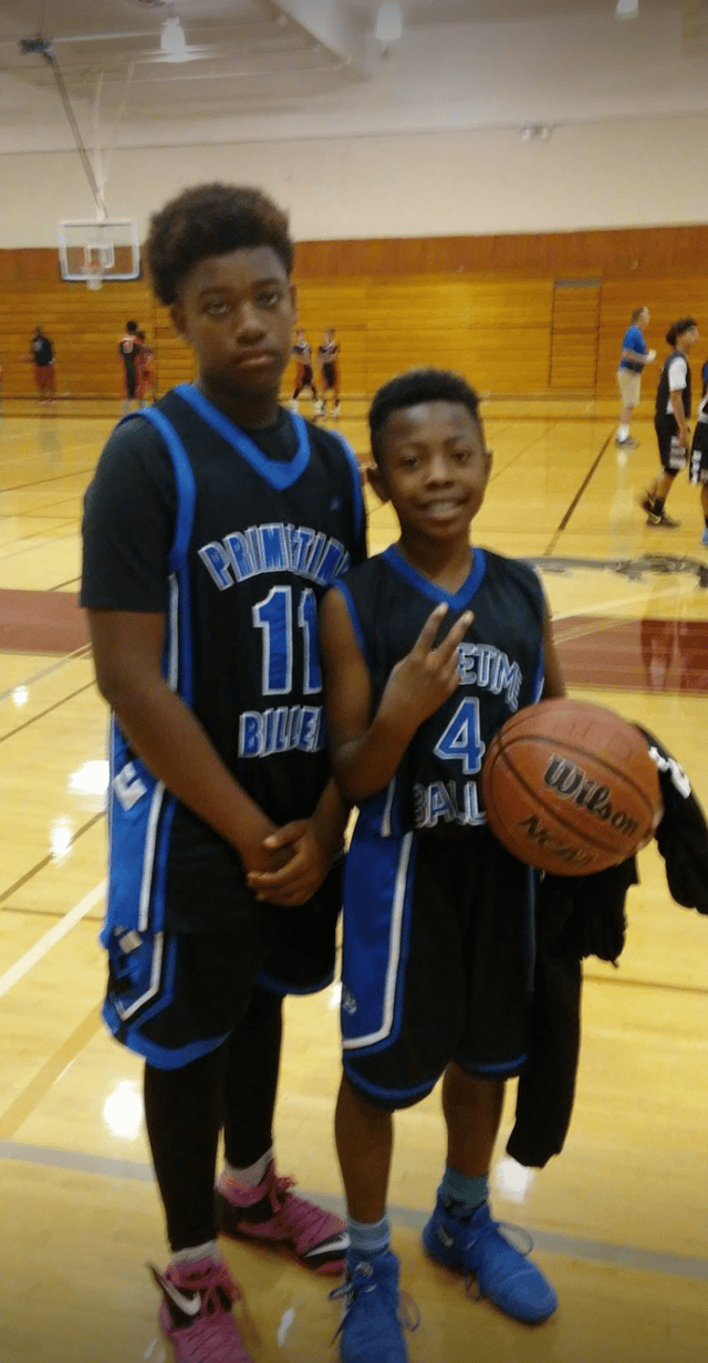 Photo of Quaylon at a basketball game with a teammate.