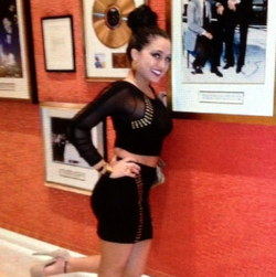 Rachael DelTondo posing next to records.