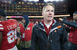 Photo of Shawn Eichorst out in the football field along with the other players.