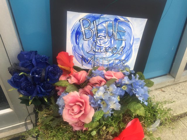 Memorial poster and flowers outside Steven Disario's police station