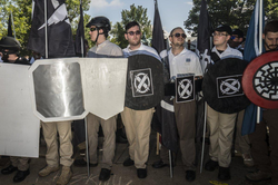 Photo of James Alex Fields Jr. (center) holding a Vanguard America and wearing their uniform